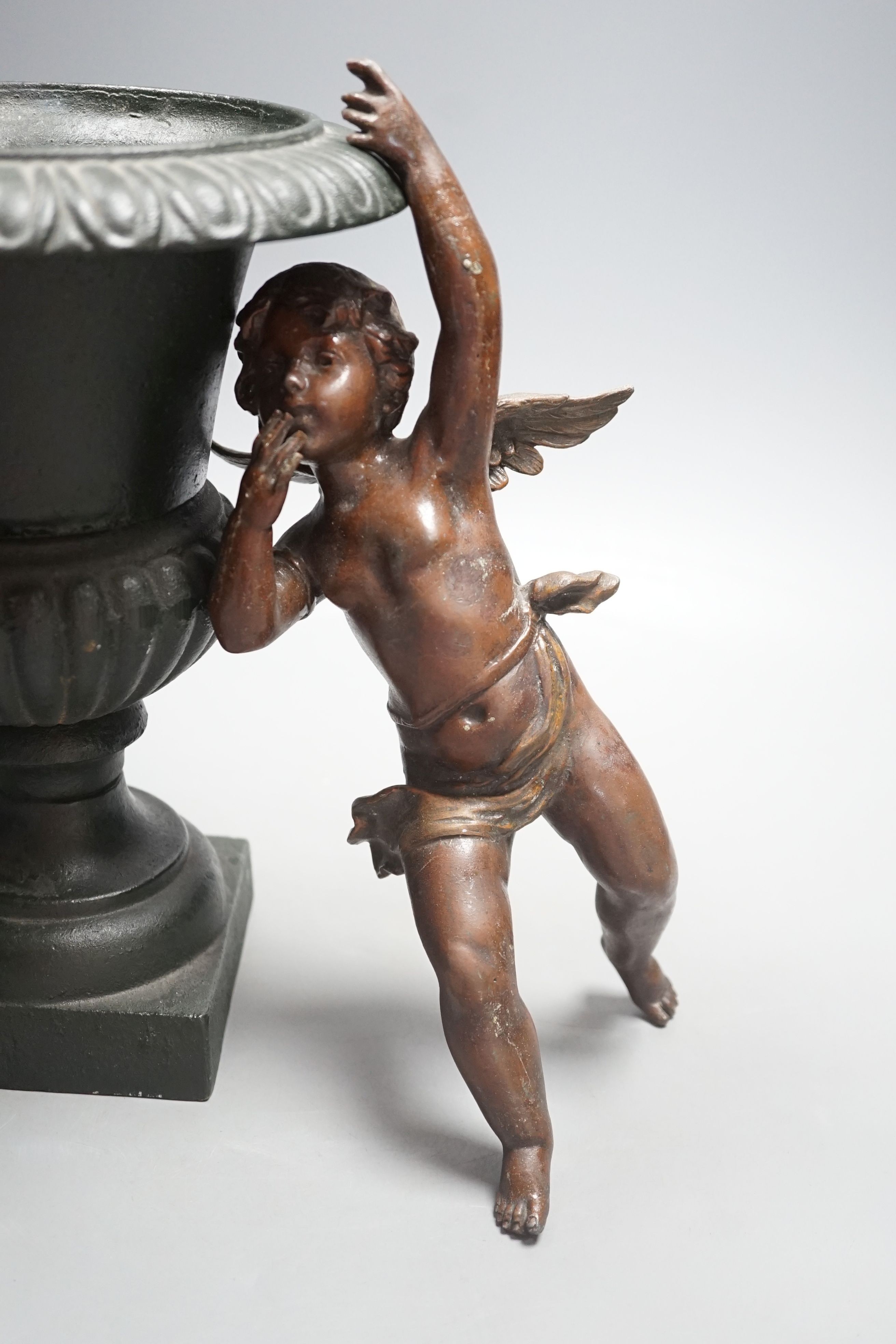 A bronzed cherub figure and a cast iron urn- 27cms high.